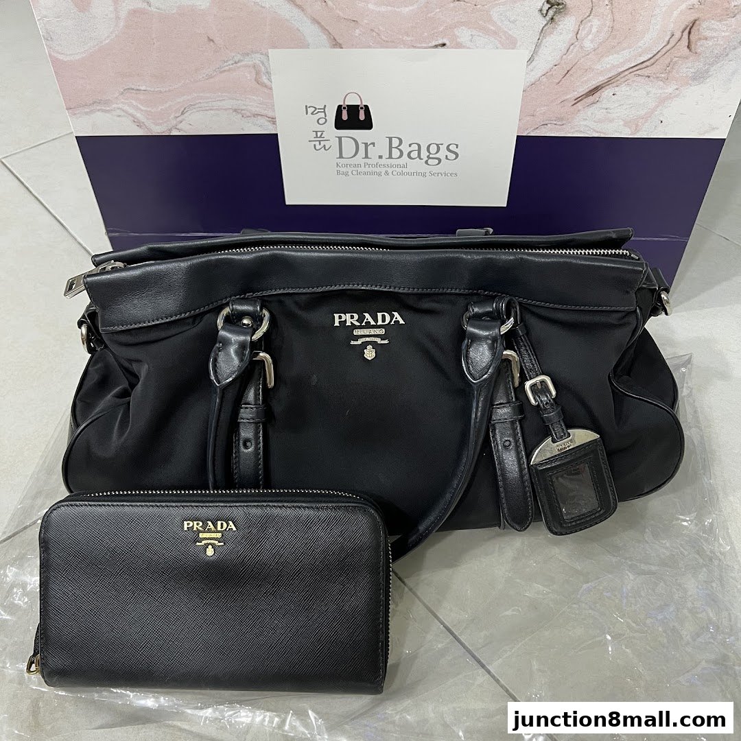 A black Prada handbag and wallet are displayed against a backdrop with the Dr. Bags logo.