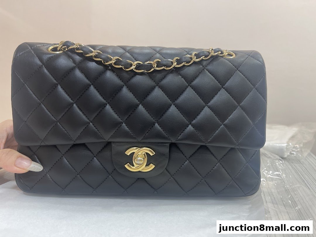 A black quilted leather handbag with a gold chain strap and clasp.