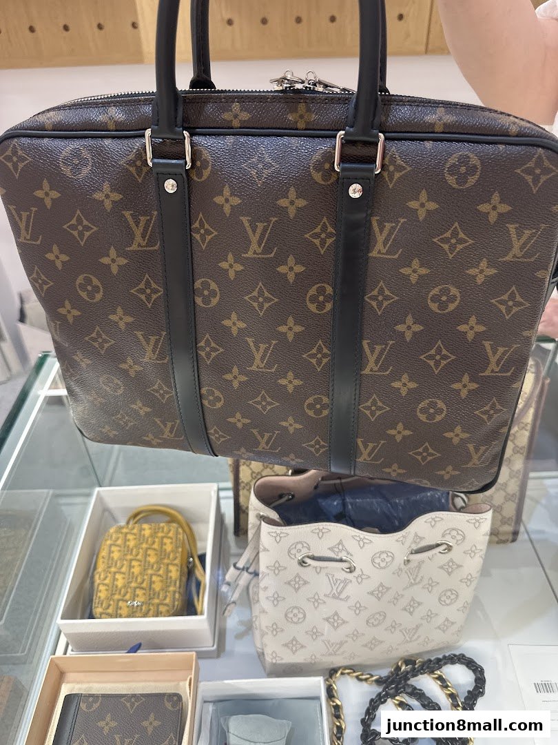 A display of luxury handbags and accessories, featuring iconic monogram patterns.