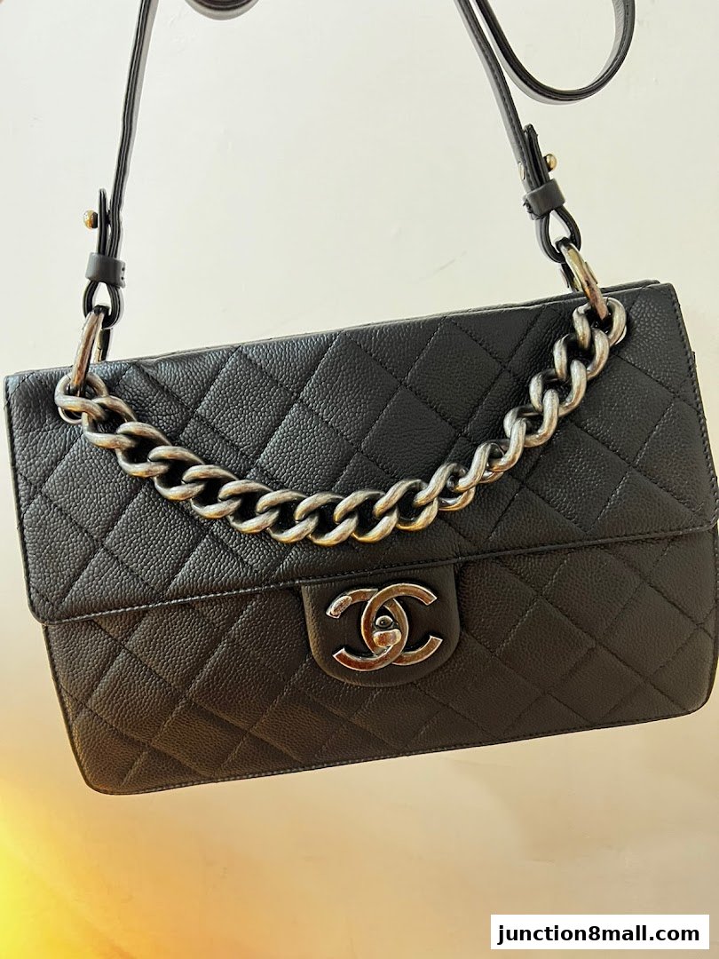 A black quilted leather handbag with a silver chain strap and iconic interlocking logo.