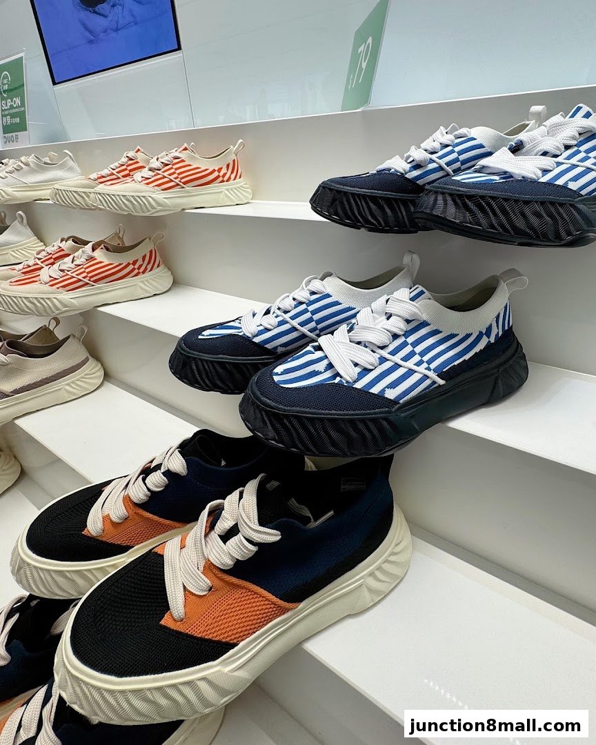 A display of stylish sneakers with various striped patterns and color combinations on white shelves.