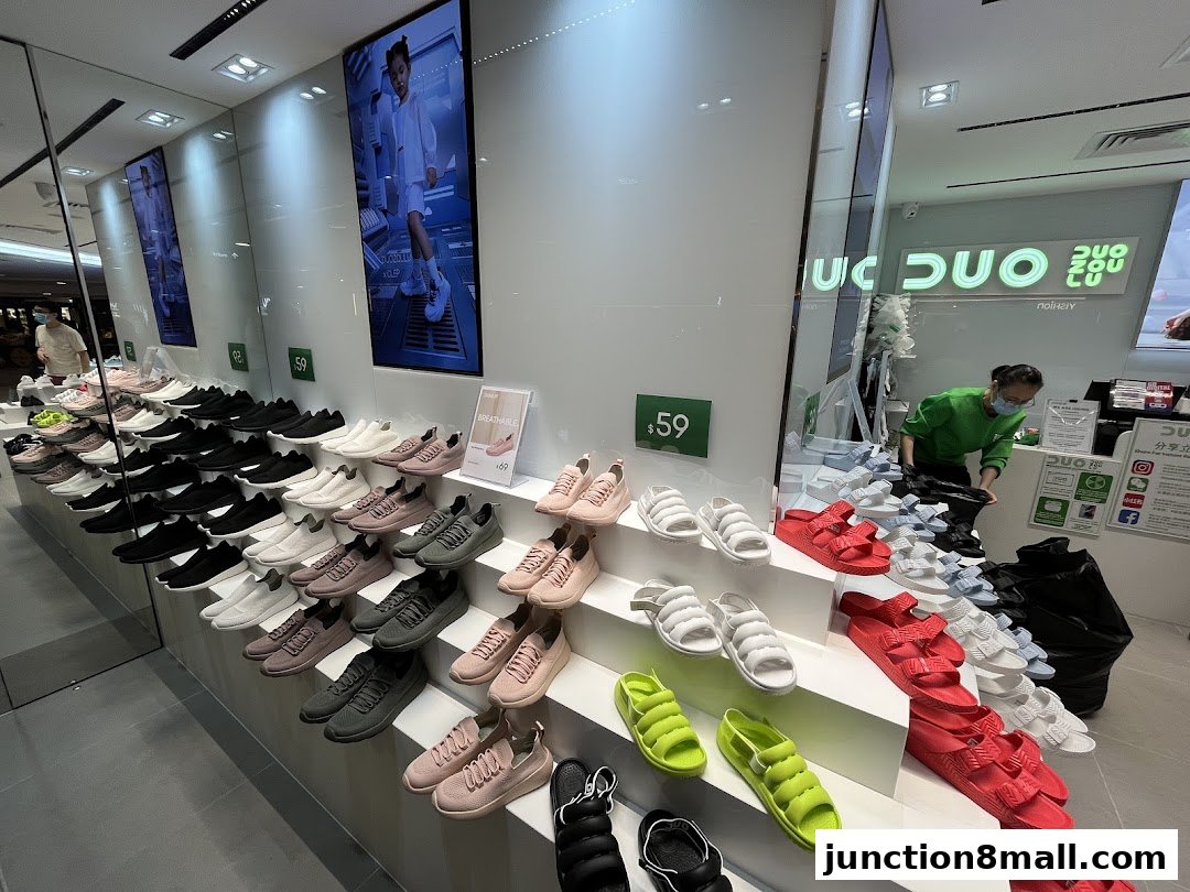 A brightly lit shoe store displaying a wide variety of sneakers and sandals in multiple colors.