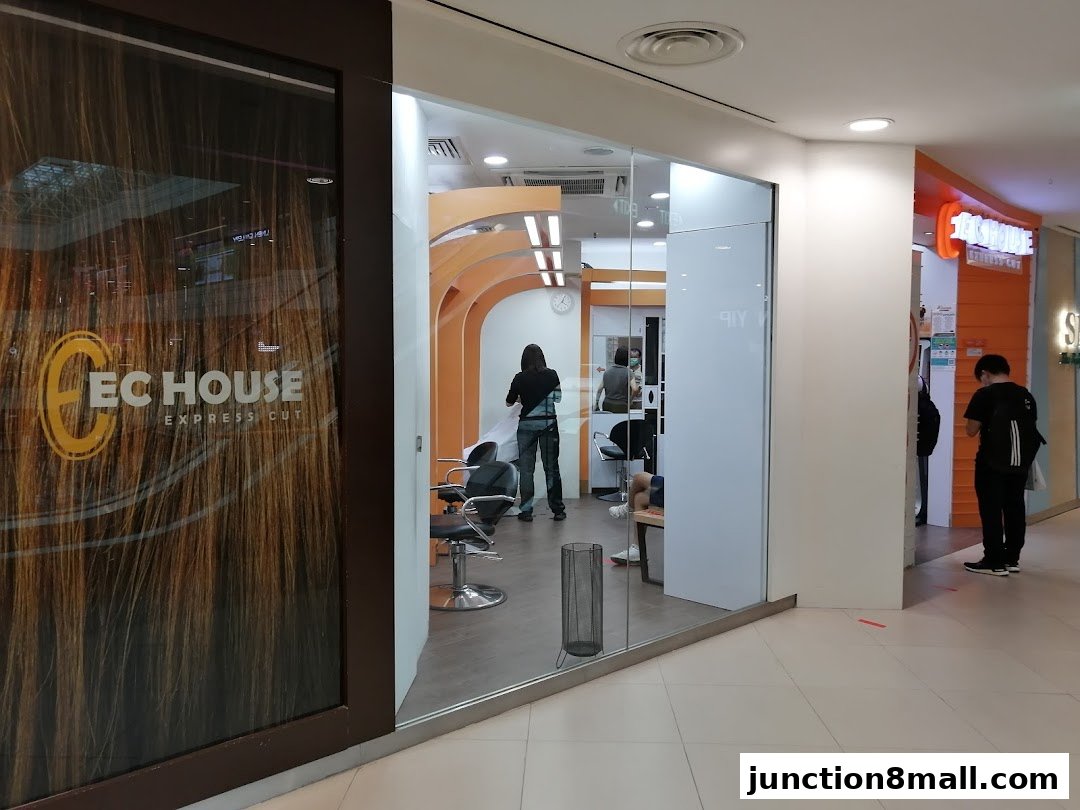 The exterior of EC House Express Cut hair salon with a large window displaying the brand logo and interior.