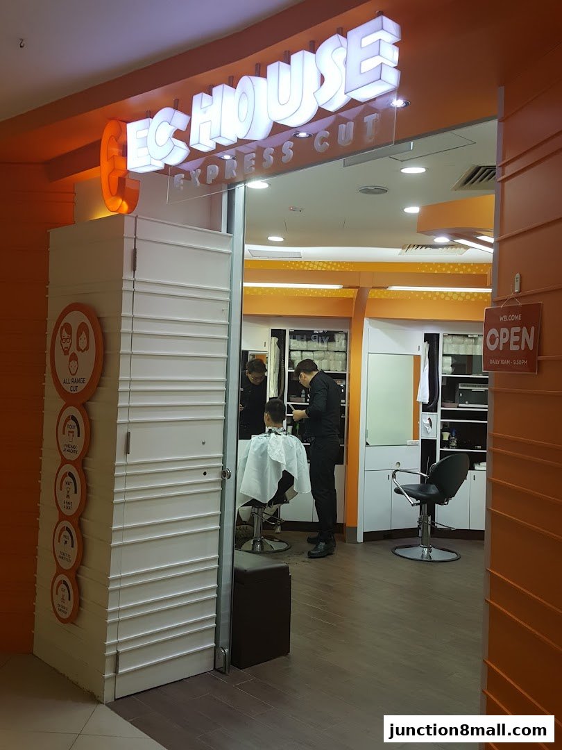The entrance of EC House Express Cut hair salon with a barber cutting a customer's hair.