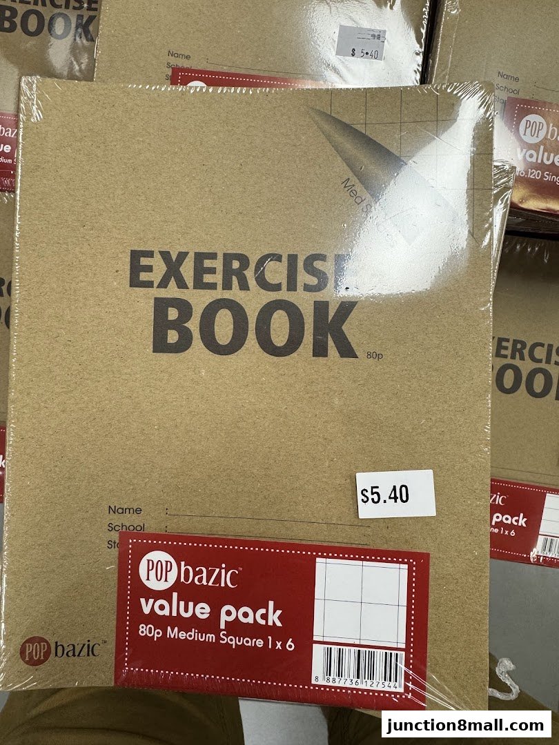 A stack of packaged exercise books with a price tag of $5.40.