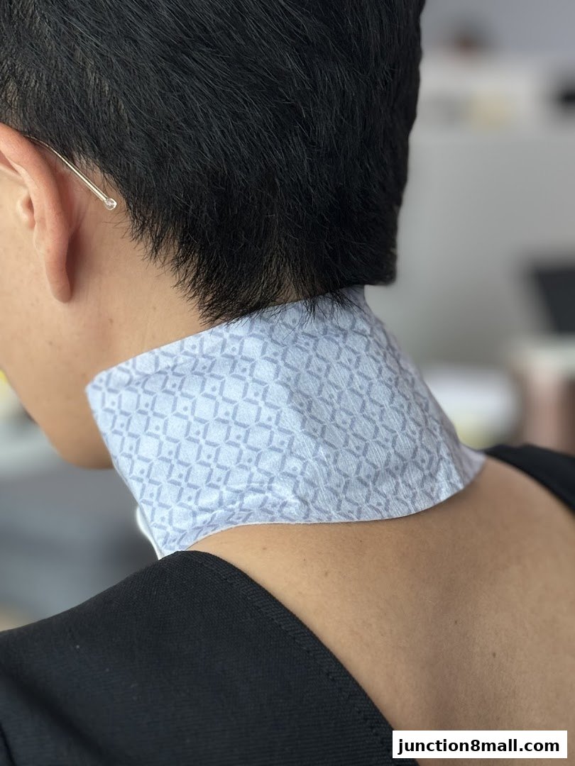 Close-up of a person wearing a patterned neck accessory and black top.