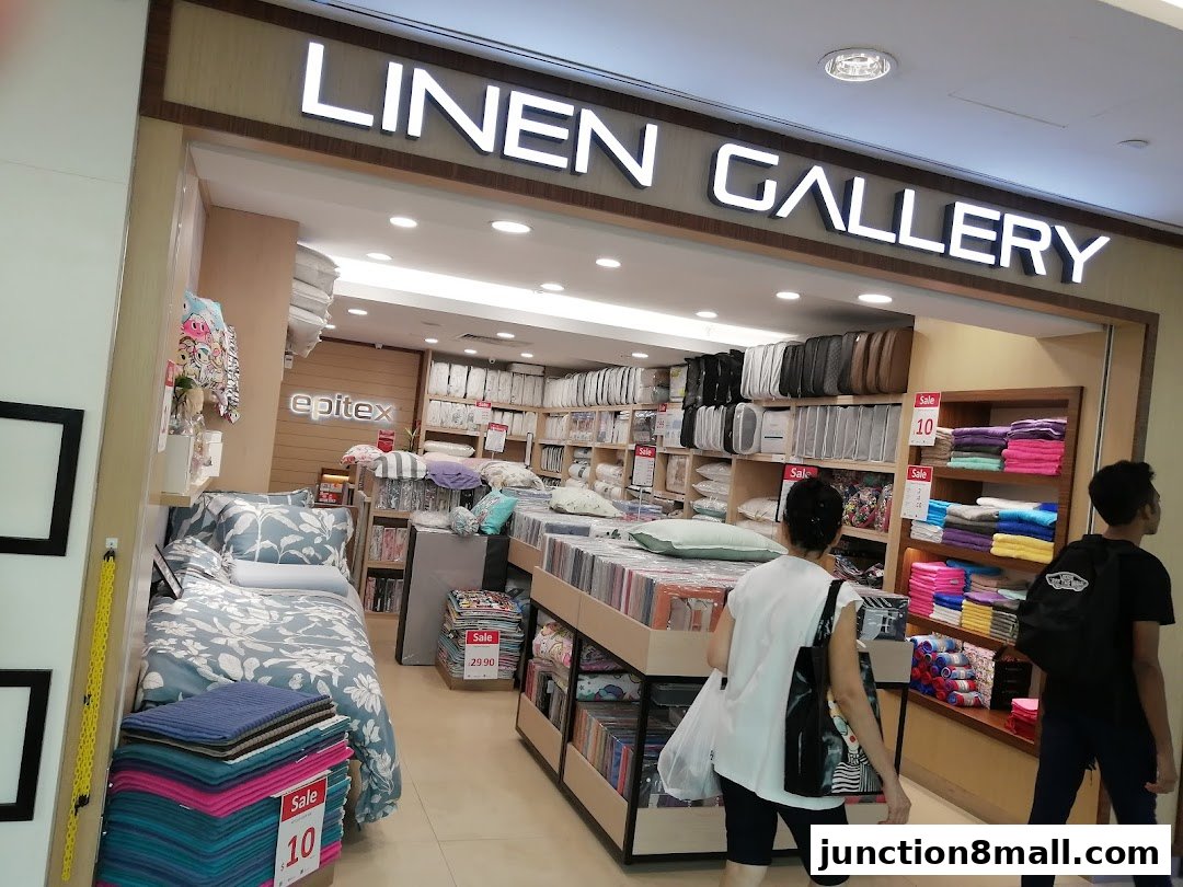 Interior view of a bedding and linen store with displays of bedding, towels, and pillows.