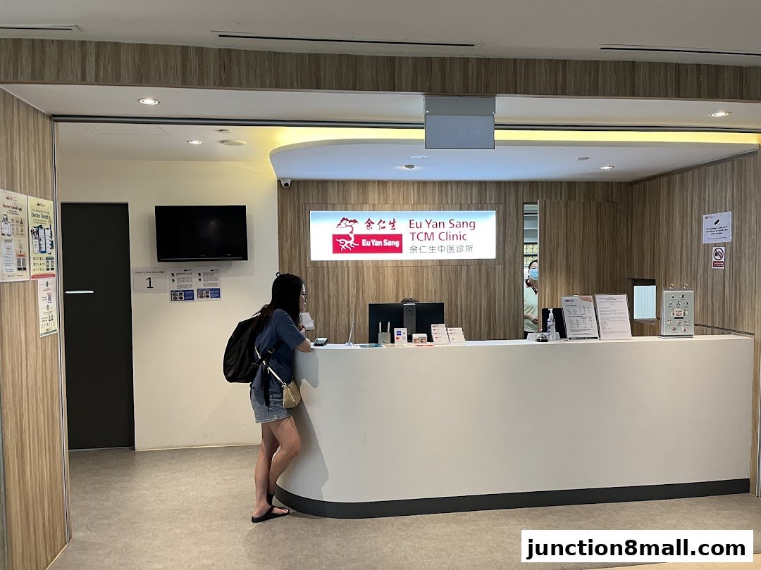 A woman stands at the reception counter of Eu Yan Sang TCM Clinic.