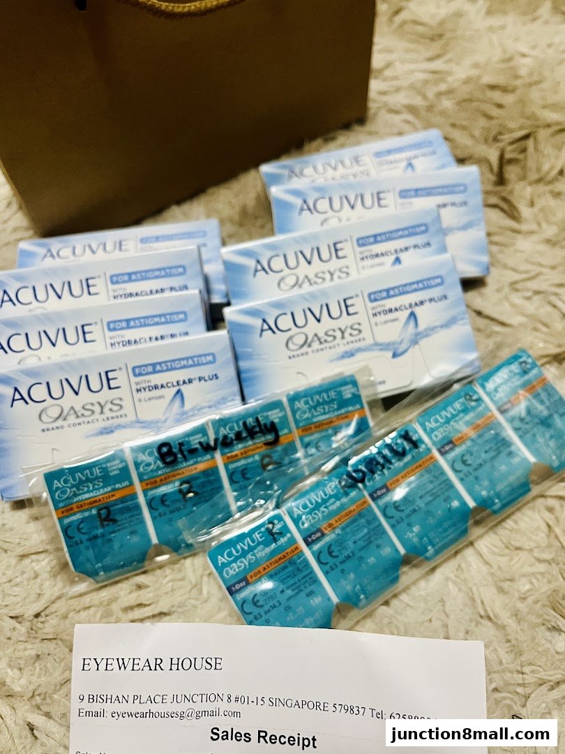 A collection of ACUVUE Oasys contact lens boxes and blister packs with a sales receipt.