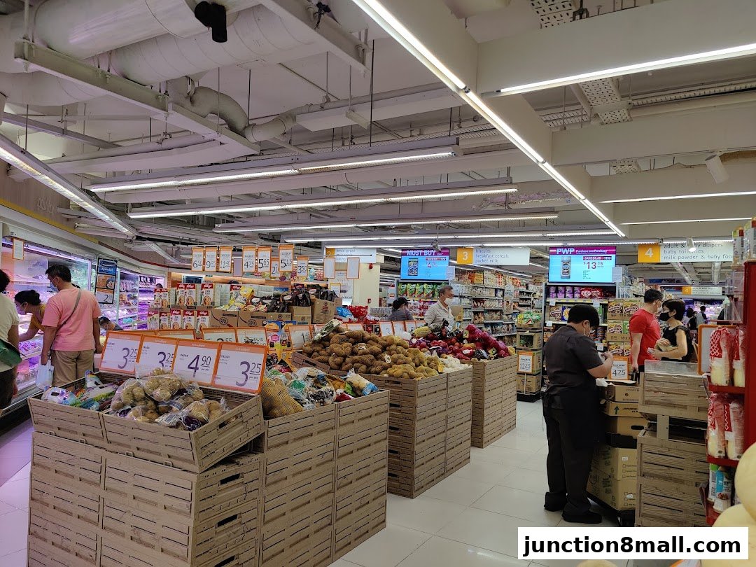 Interior view of a FairPrice Finest supermarket with fresh produce and aisles of groceries.