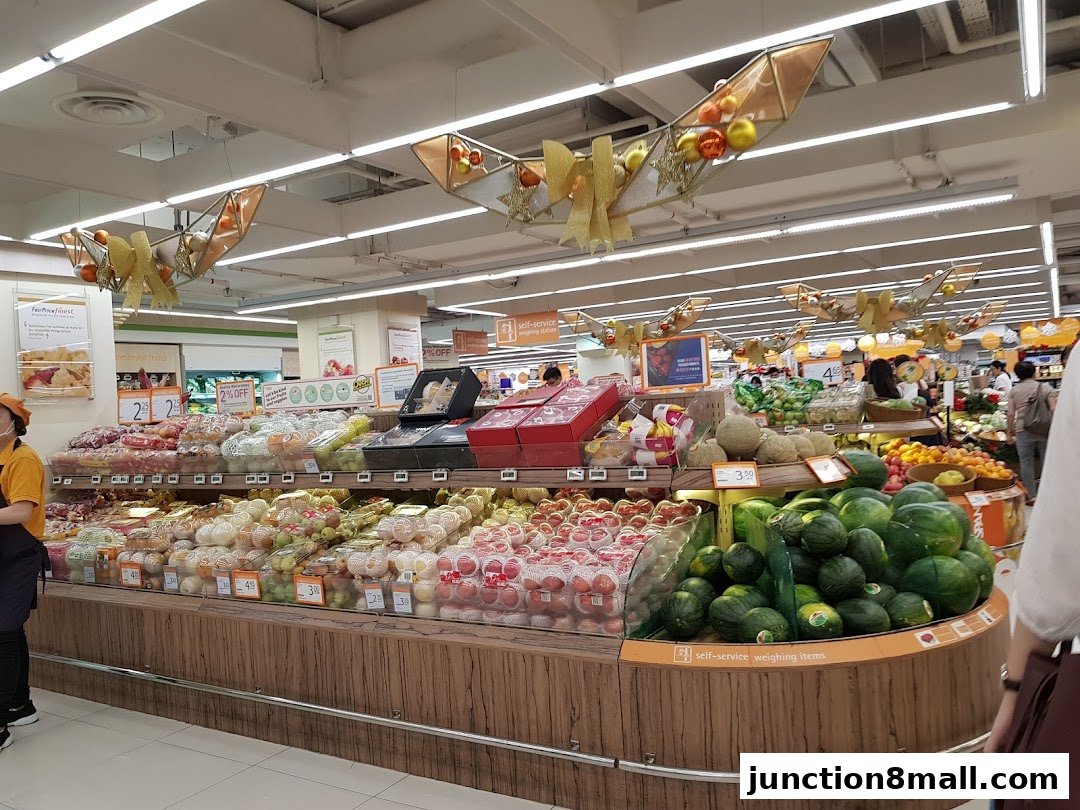 A wide selection of fresh fruits and vegetables displayed in a supermarket aisle.