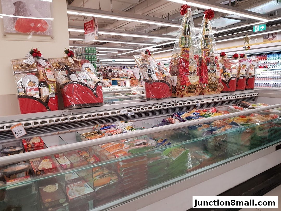 A grocery store aisle featuring festive gift baskets and frozen food displays.
