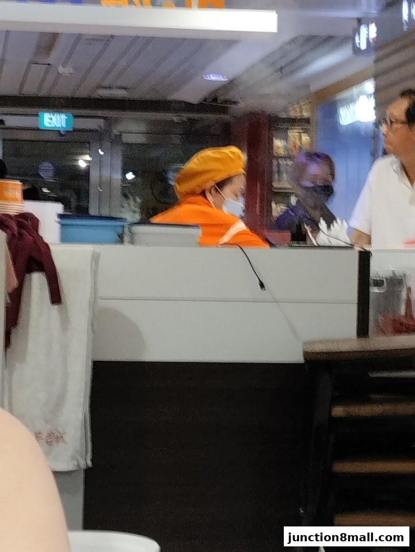 Staff members in uniform working behind a counter at Fei Siong.