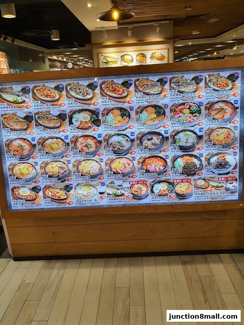 A digital menu board displaying various Korean dishes with images and prices.