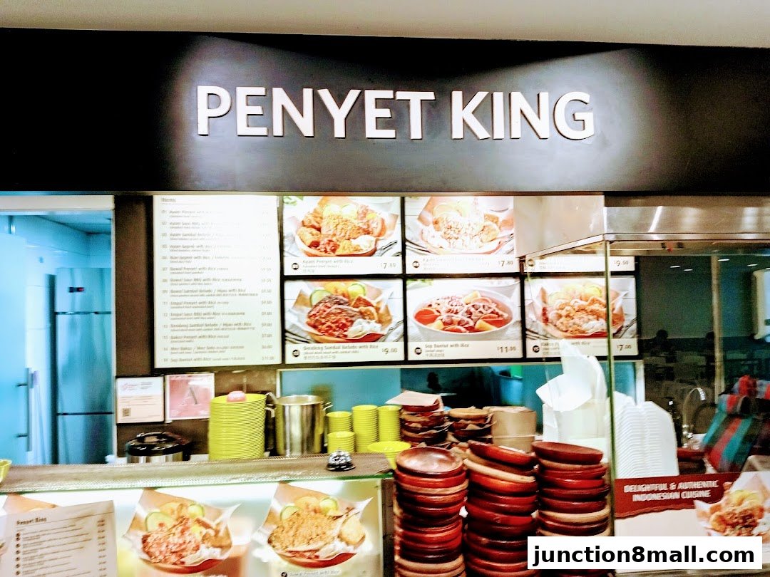 A food stall counter displaying a menu and images of Indonesian dishes.