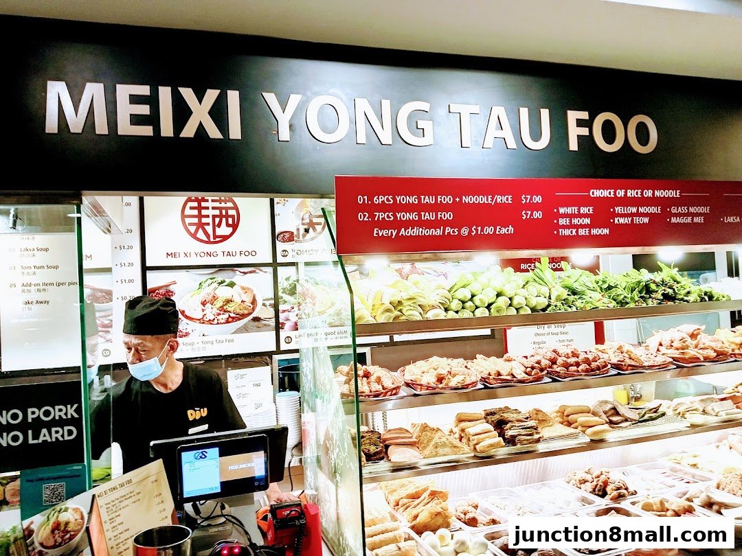 A food stall display with a variety of Yong Tau Foo ingredients and a menu board.