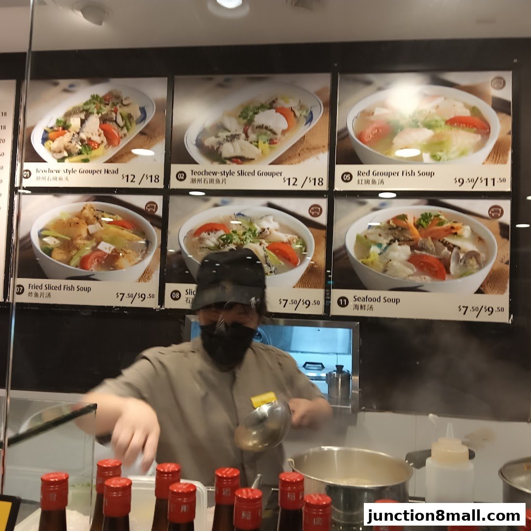 A food stall display featuring various fish soup and seafood dishes with prices.
