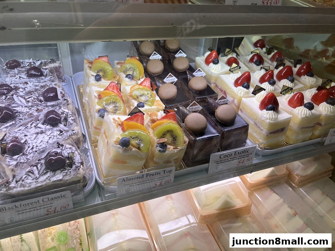A display case filled with various beautifully decorated cakes and pastries.