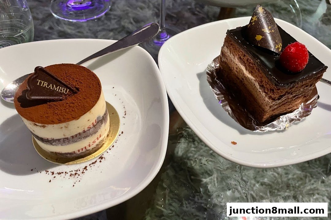 Two delicious cakes, a tiramisu and a chocolate cake, are presented on white plates.