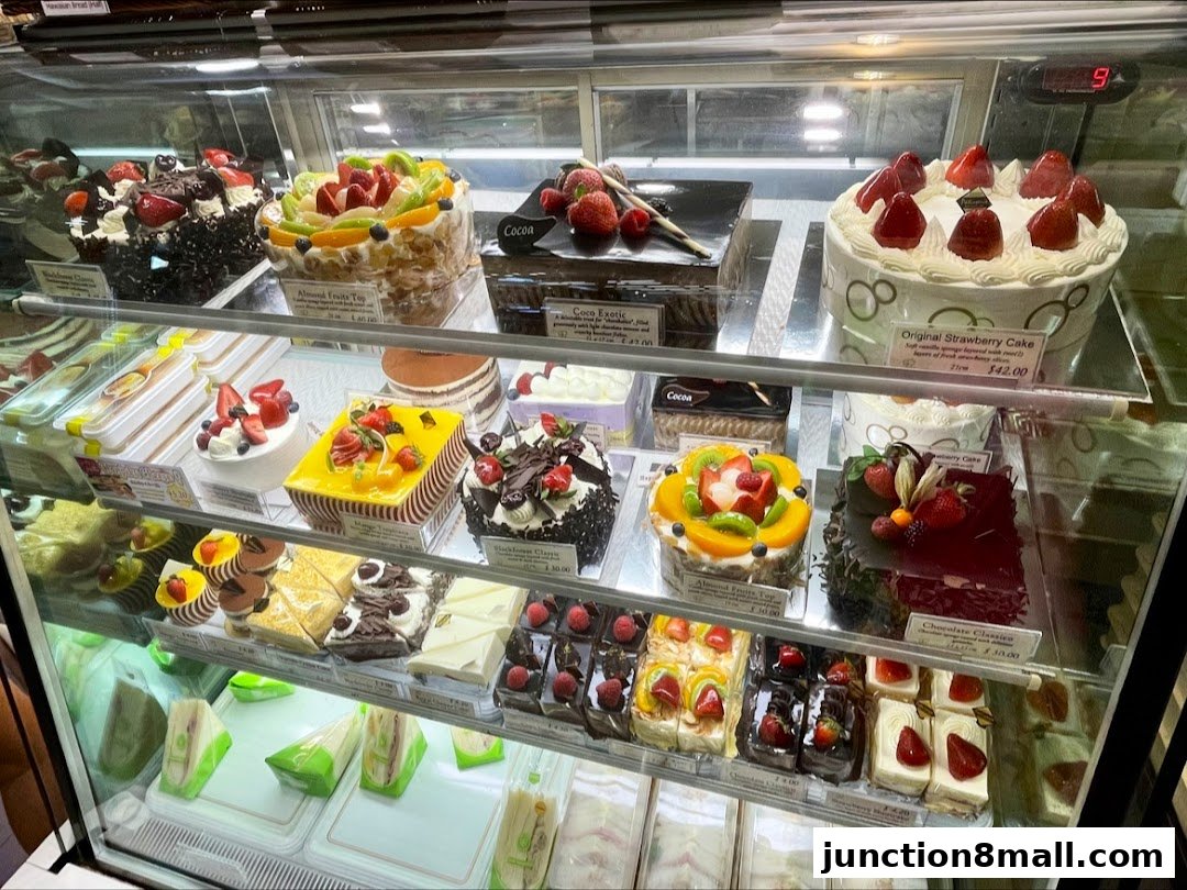 A display case filled with a variety of beautifully decorated cakes and pastries.