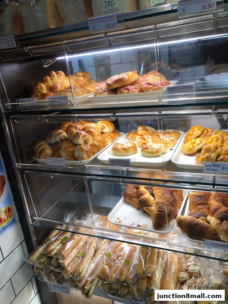 A display case filled with various baked goods including bread, pastries, and sandwiches.