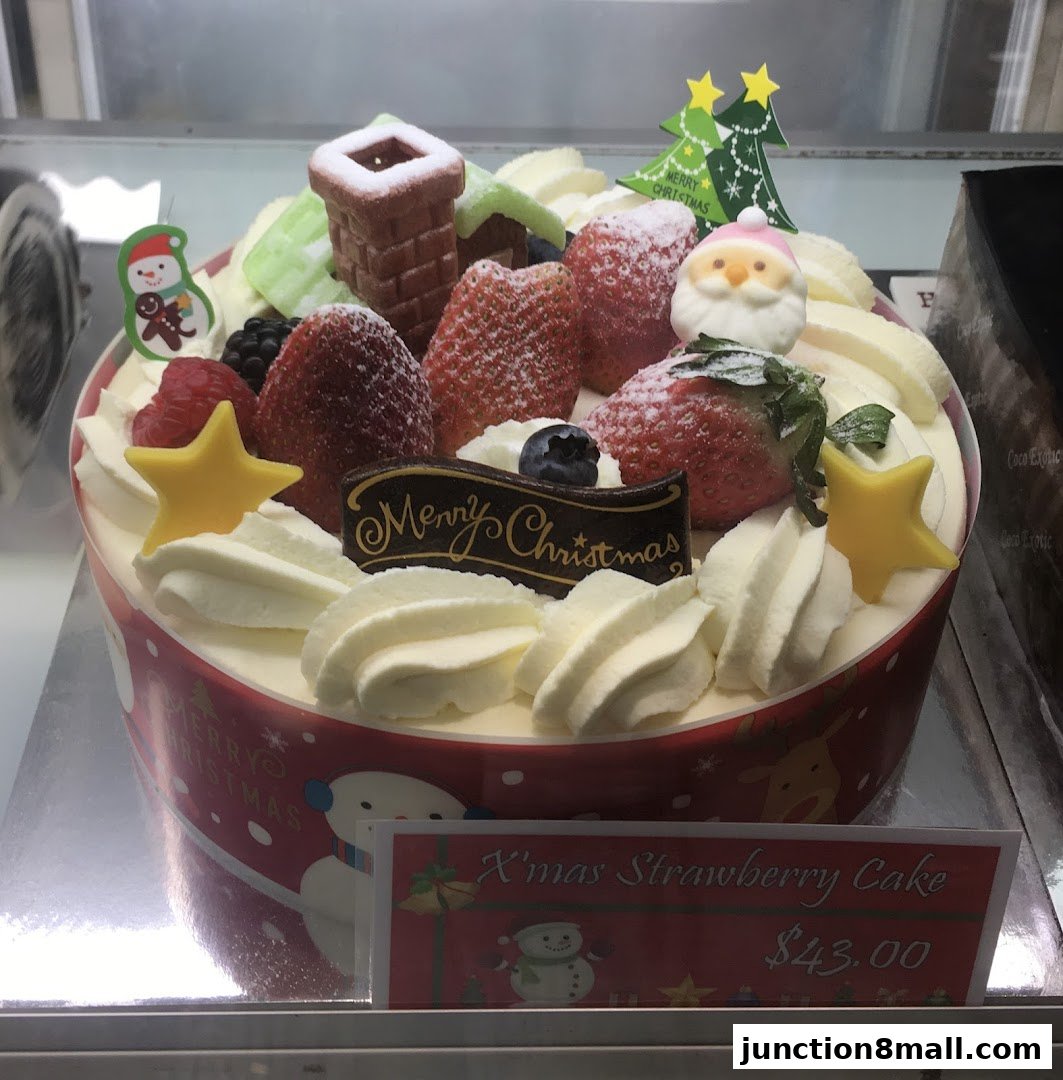 A festive Christmas cake decorated with strawberries, cream, and festive toppers.