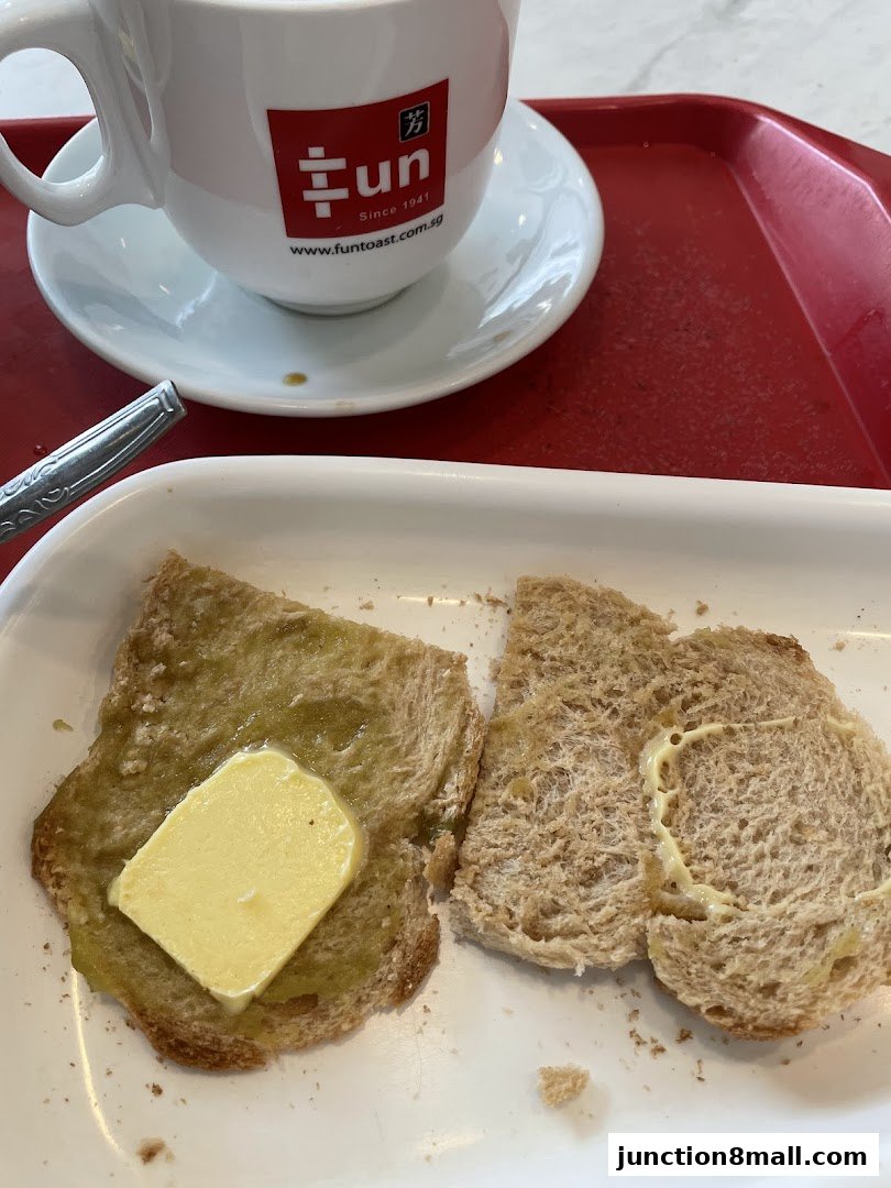 A close-up of buttered toast and a cup of coffee on a red tray.