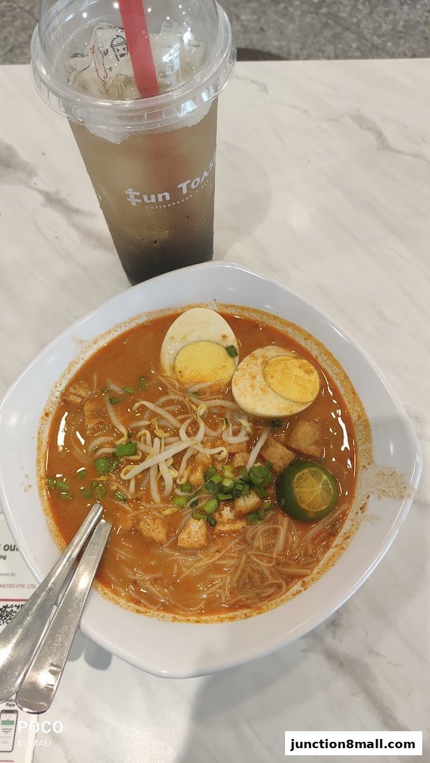 A bowl of Laksa with a drink from Fun Toast.