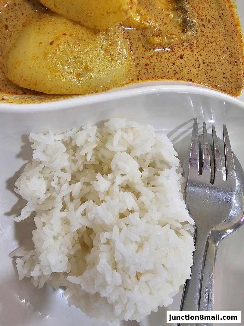A close-up of a delicious meal featuring fluffy white rice and a rich curry with potatoes.