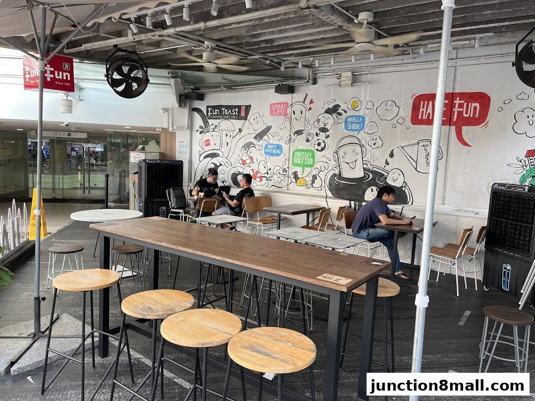 People sitting at tables inside Fun Toast with a mural on the wall.
