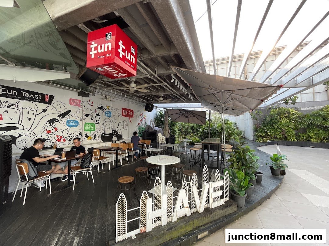 A lively outdoor seating area of Fun Toast with a mural and people enjoying their time.