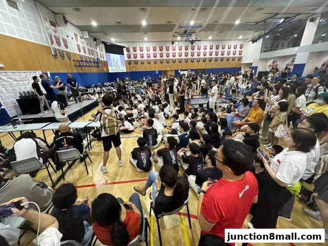 A large crowd of people, mostly students, gathered in a gymnasium for an event.