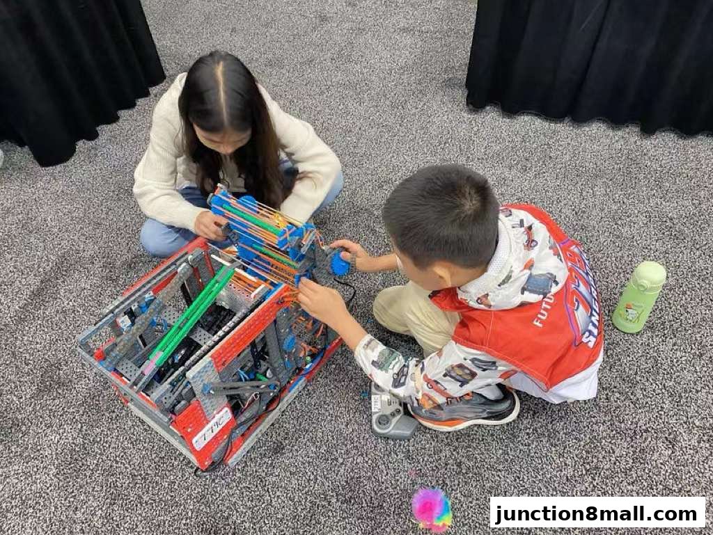 Two children are engaged in building a complex robot or engineering project.