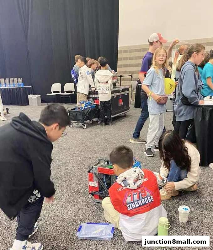 Children engaged in a robotics activity at an event, with a robot in the foreground.