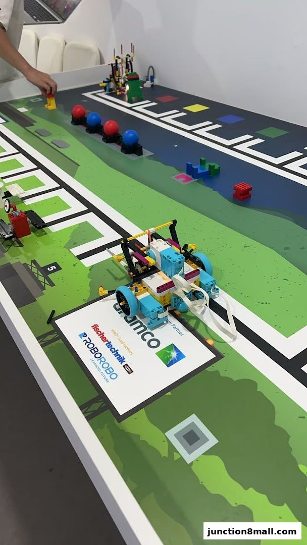 A table with a robot made of LEGOs and a game board for a robotics competition.