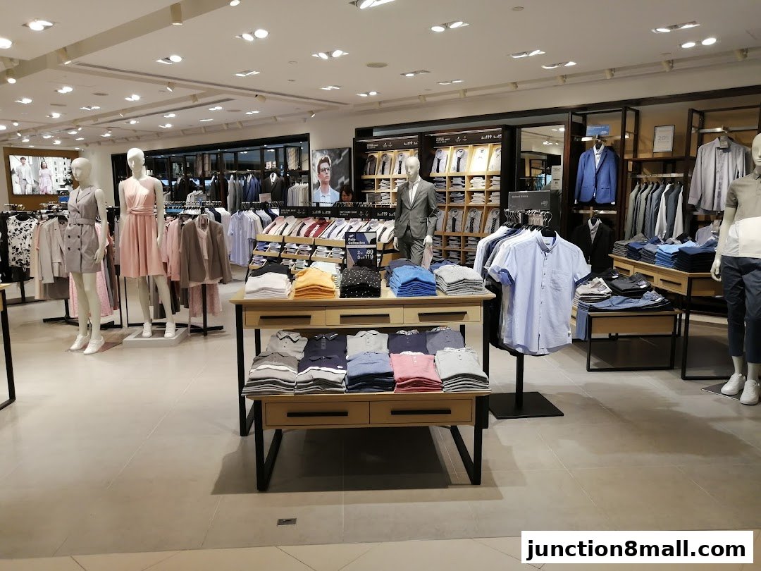 Interior view of a G2000 clothing store showcasing men's and women's apparel on mannequins and racks.