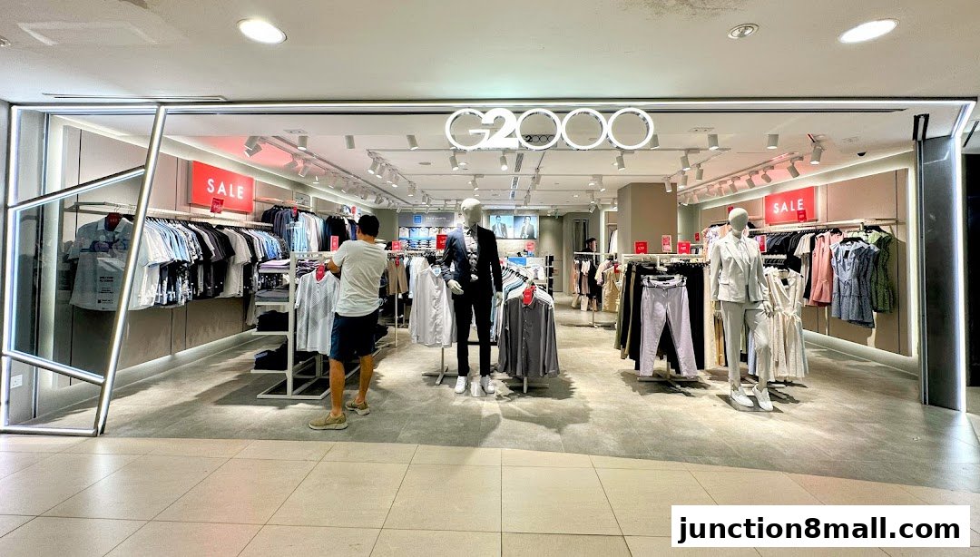 G2000 clothing store interior with mannequins and sale signs.