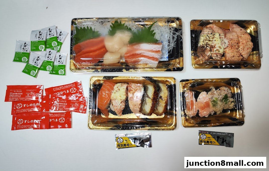 A variety of sushi and sashimi dishes in takeaway containers, with soy sauce and wasabi packets.