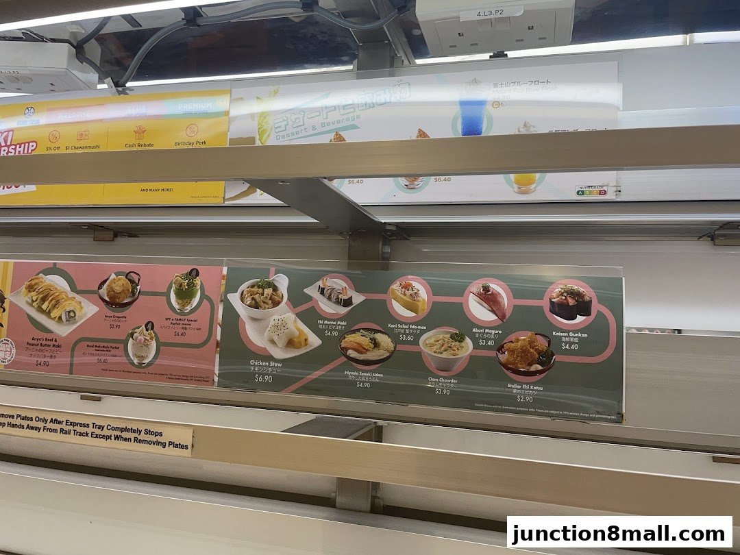 A display of various sushi dishes and desserts offered at Genki Sushi Junction 8.