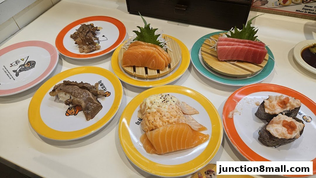 Plates of sushi and sashimi are arranged on a table, showcasing various seafood and meat dishes.