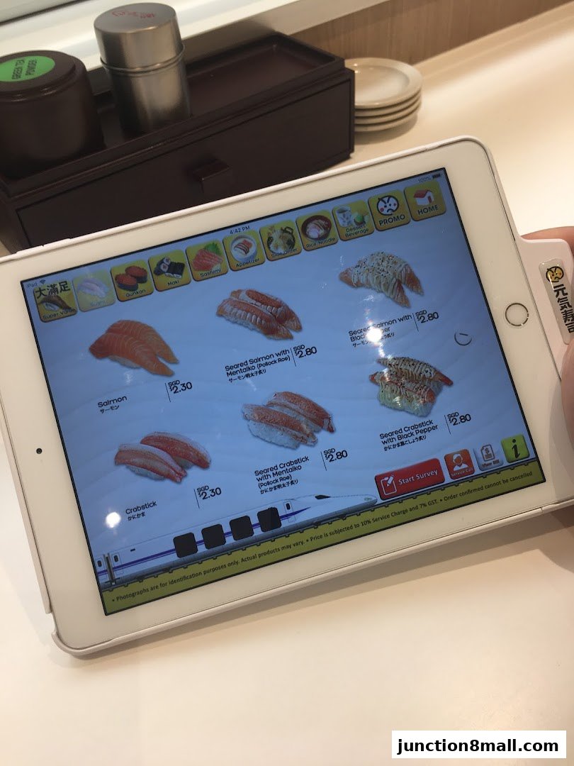 A tablet displays a menu of sushi items with prices and images.