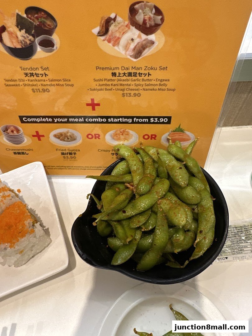 A close-up of a sushi menu with various set meals and side dishes, featuring edamame.