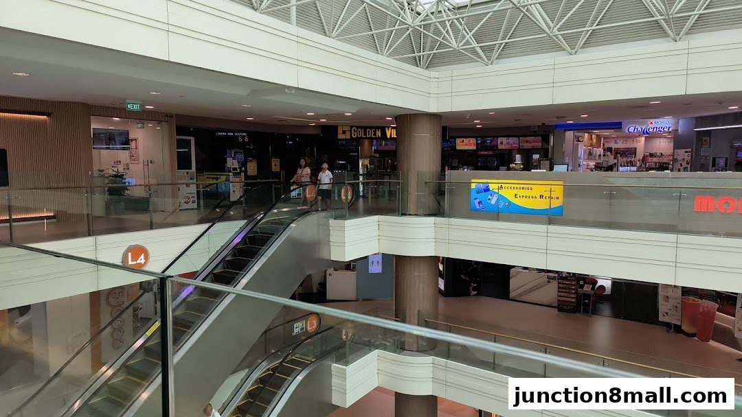 Interior view of a shopping mall with escalators and various shops including Golden Village.