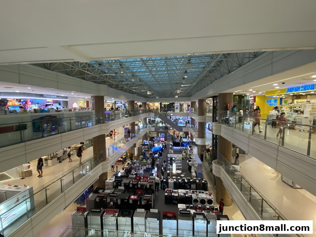 An interior view of a multi-level shopping mall with various shops and escalators.