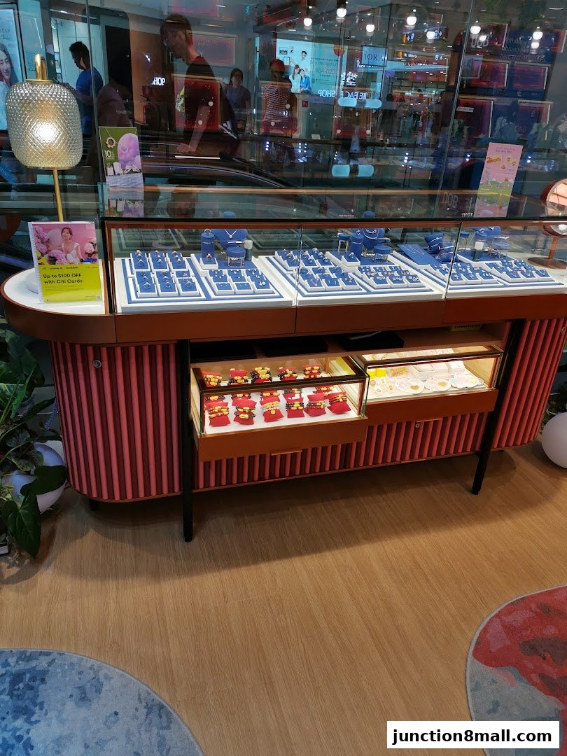 A jewelry display case filled with necklaces and bracelets, with a promotional sign.