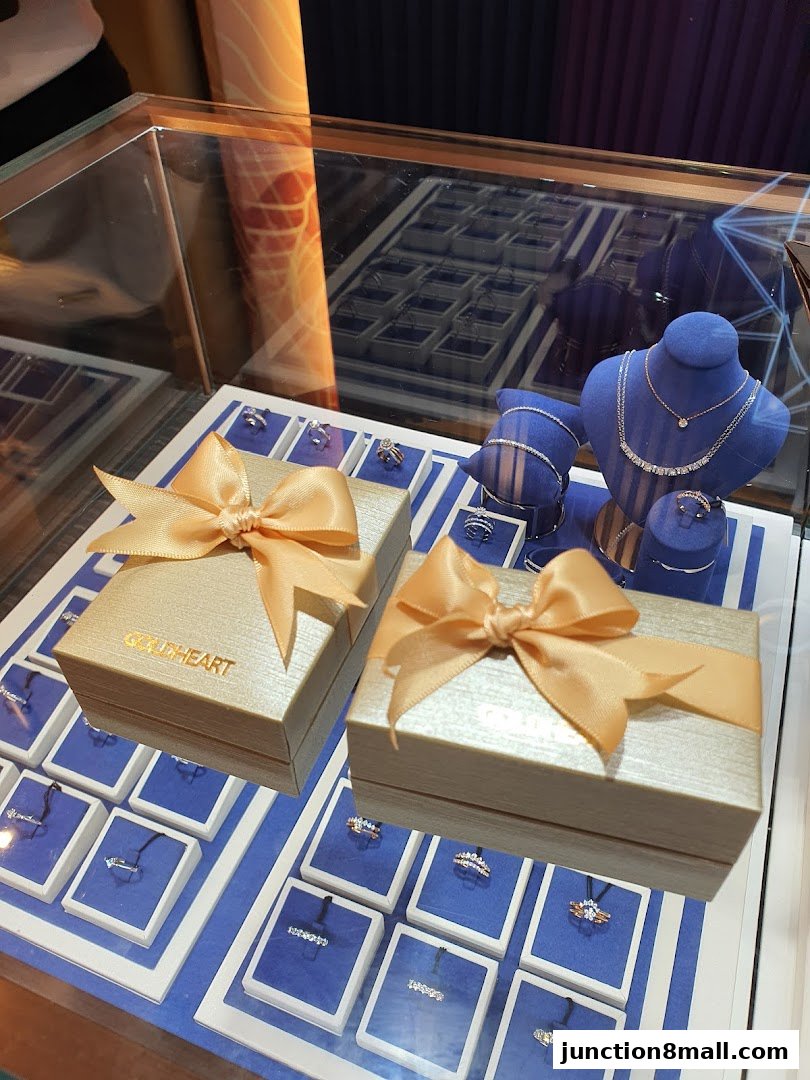 A display case filled with elegant jewelry, including rings and necklaces, with gift boxes.