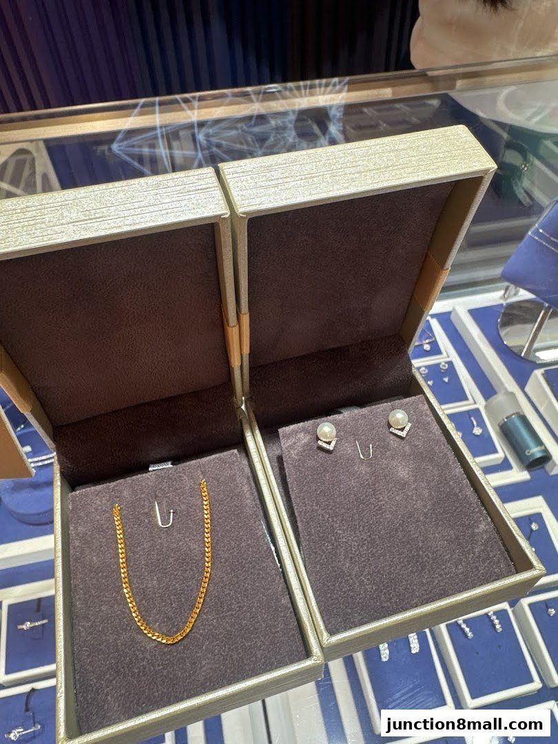 Two jewelry display boxes showcasing a gold chain and pearl earrings.