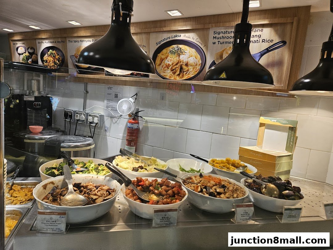 A display of various dishes in bowls at a food stall, with menu posters above.
