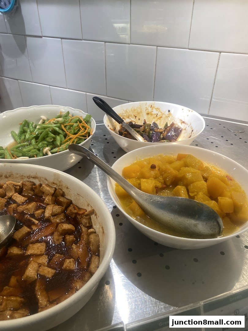 A selection of four bowls of food, including green beans, eggplant, tofu, and pumpkin.