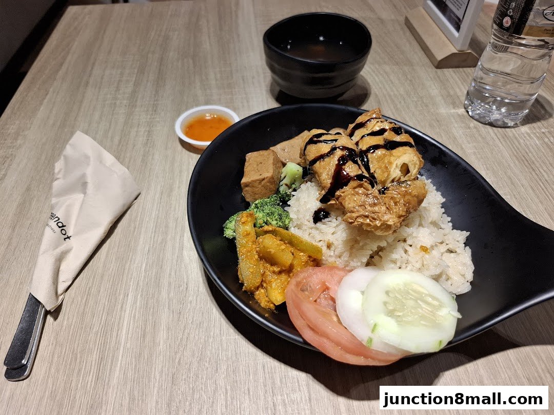 A delicious meal from Greendot Junction 8 featuring rice, tofu, vegetables, and a side of soup.
